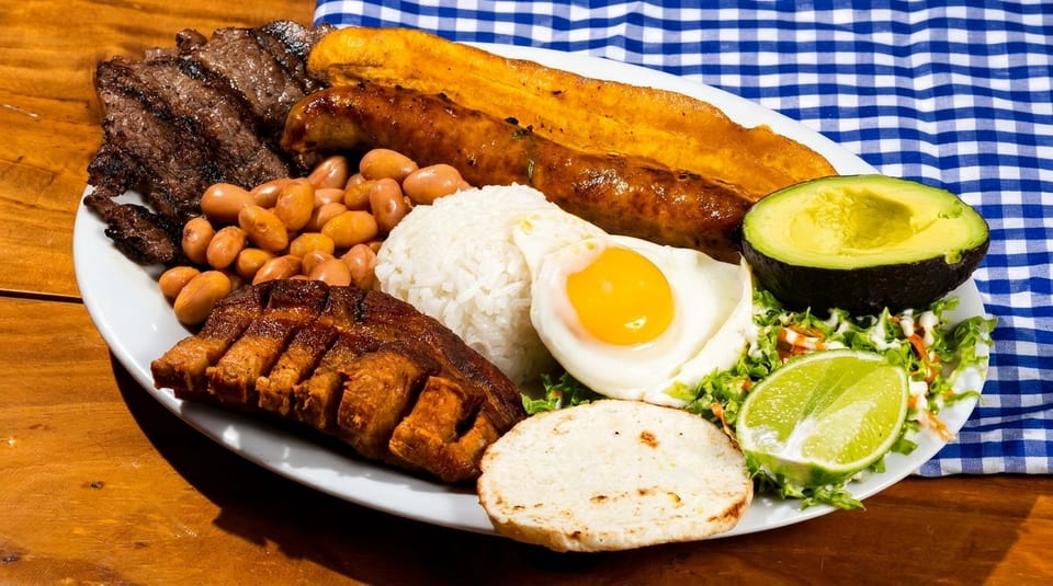 A large platter of Bandeja Paisa with grilled steak, beans, rice, egg, avocado, and plantain.